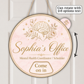 A round hanging personalized sign with a pale pink marble background and gold illustration of a brain, flowers, and stars. The sign reads 'Sophia's Office' and 'Mental Health Coordinator / Scheduler' with 'Come on in' at the bottom.